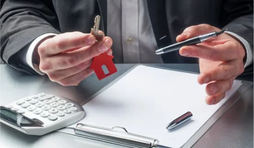 letting agent holding pen and keys over signing documents